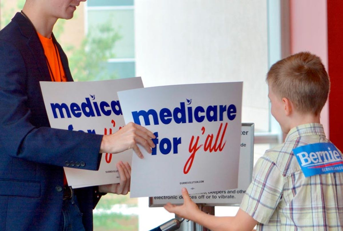 A volunteer hands out a poster as Vermont independent Sen. Bernie Sanders was set to address a “Medicare for All” rally in downtown Columbia, S.C. on Saturday, Oct. 20, 2018 (AP/Meg Kinnard)