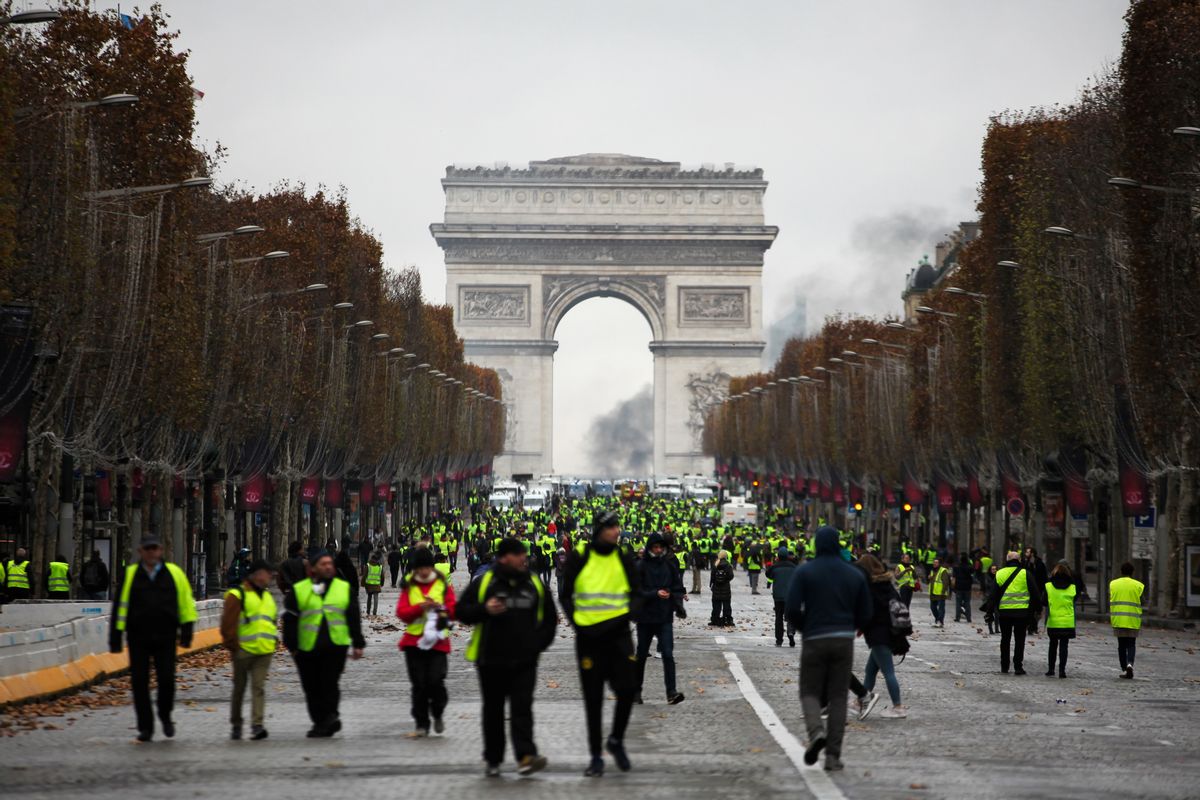 Demonstrators walk near the Arc de Triomphe during a protest of "yellow vests." (Gilets jaunes) against rising oil prices and living costs, on December 1, 2018 in Paris. - Anti-government protesters torched dozens of cars and set fire to storefronts during daylong clashes with riot police across central Paris on December 1, as thousands took part in fresh "yellow vest" protests against high fuel taxes.  (Afp/getty Images)
