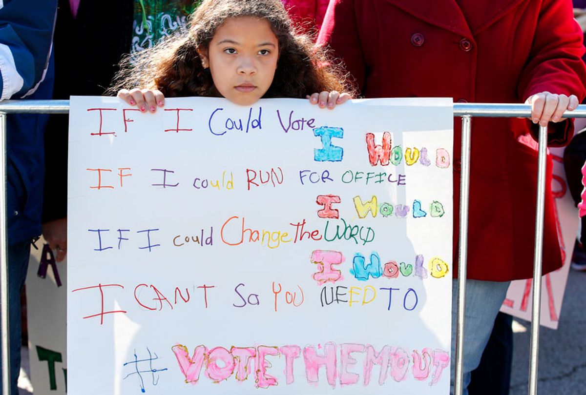 A young girl listens as women gather for a rally and march at Grant Park on October 13, 2018 in Chicago, Illinois to inspire voter turnout ahead of midterm polls. (Getty/Kamil Krzaczynski)