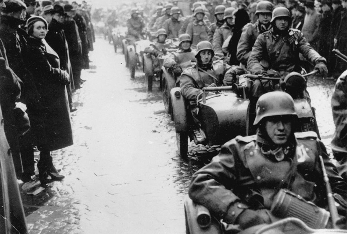 German Nazis riding in a convoy of motorcars invade Prague as people line the streets and watch silently in the rain and sleet on March 15, 1939 during the Czech German Occupation. (AP Photo)