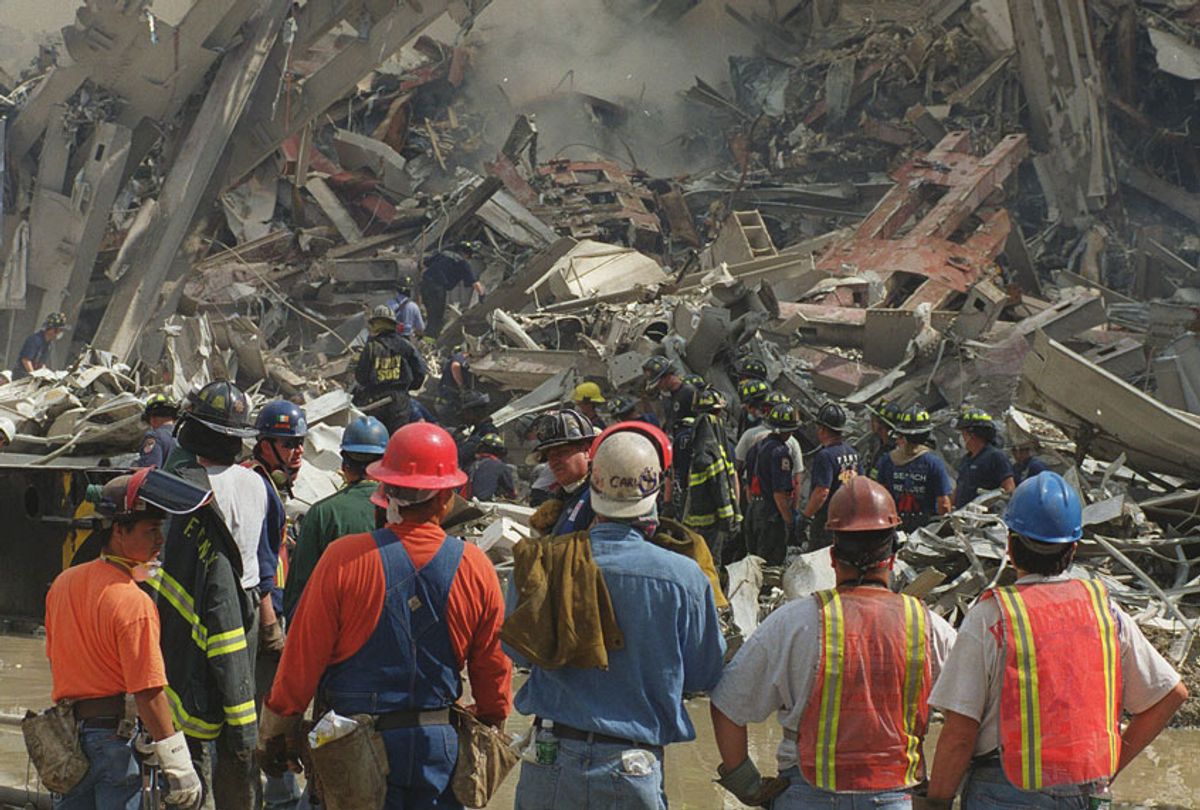 Rescue workers look over the rubble of the World Trade Center towers in New York, Wednesday, Sept. 12, 2001. (AP/Virgil Case)