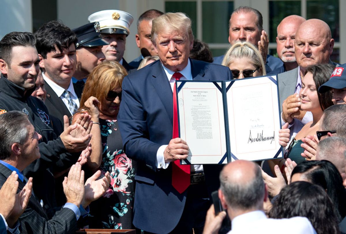 People applaud as US President Donald Trump, surrounded by September 11 first responders and family members, signs HR 1327, an act to permanently authorize the September 11th victim compensation fund, during a ceremony in the Rose Garden of the White House in Washington, DC, July 29, 2019.  (Getty/Saul Loeb)