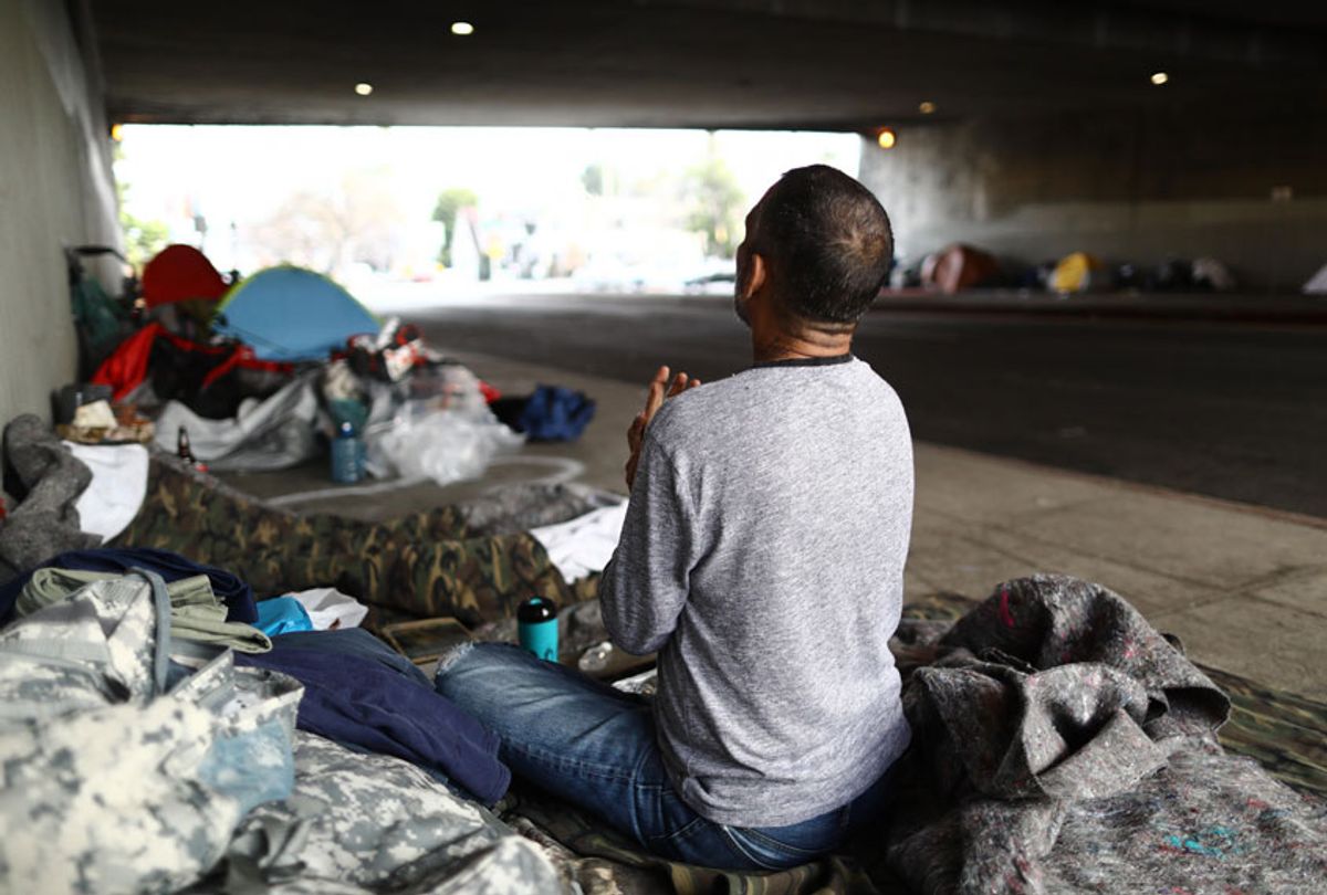 Travis Stanley, who said he has been homeless for three months and is a U.S. Navy veteran, sits on donated bedding, where he normally sleeps, beneath an overpass on June 5, 2019 in Los Angeles, California. (Getty/Mario Tama)