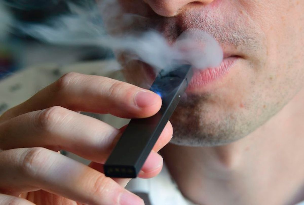 An illustration shows a man exhaling smoke from an electronic cigarette in Washington, DC on October 2, 2018. - In just three years, the electronic cigarette manufacturer Juul has swallowed the American market with its vaporettes in the shape of a USB key. Its success represents a public health dilemma for health authorities in the United States and elsewhere. (Photo by EVA HAMBACH / AFP)        (Photo credit should read EVA HAMBACH/AFP/Getty Images) (Eva Hambach/AFP/Getty Images)