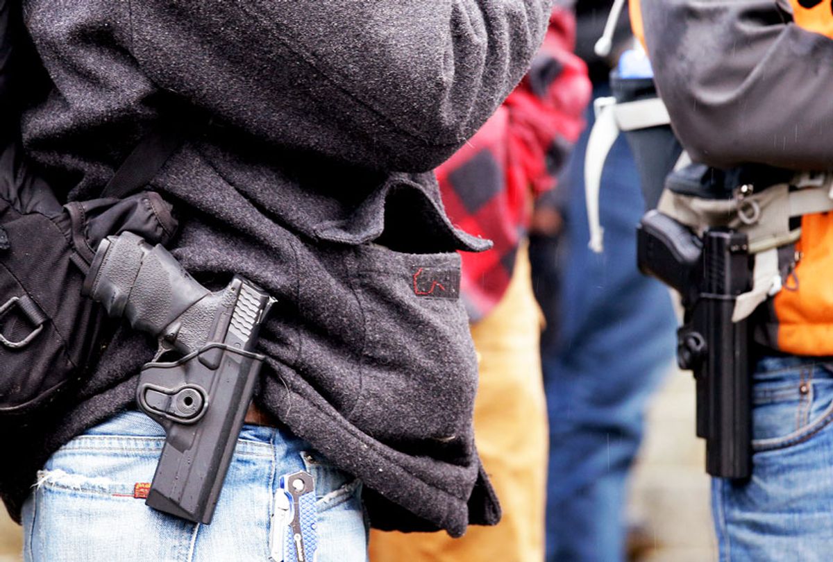 Men stand with pistols strapped at their sides at a gun rights rally on the steps of the Capitol Friday, Jan. 15, 2016, in Olympia, Wash. (AP Photo/Elaine Thompson)