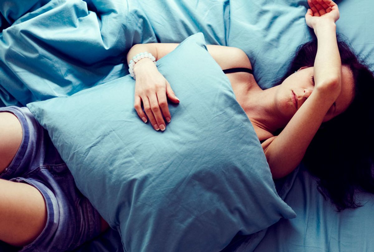 Depressed woman in bed with hand on forehead (Getty/ Martin Dimitrov)