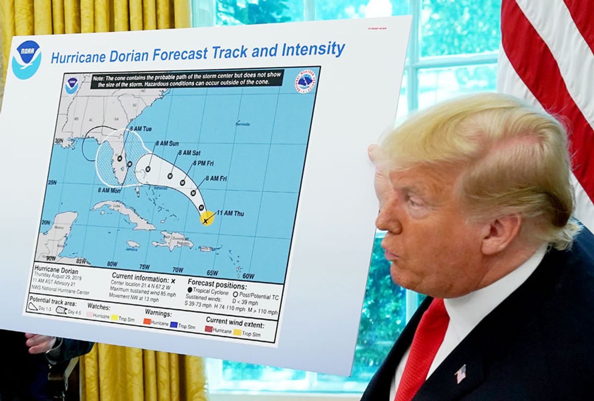 U.S. President Donald Trump (R) references a map while talking to reporters following a briefing from officials about Hurricane Dorian in the Oval Office at the White House September 04, 2019 in Washington, DC.  (Chip Somodevilla/Getty Images)