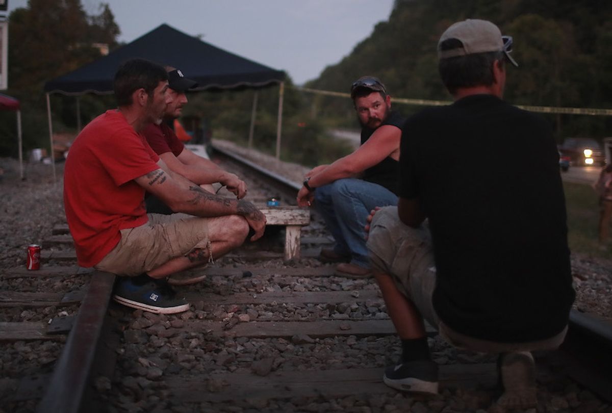 Coal miners from Blackjewel coal company pass time chatting on the railroad tracks that lead to one of the company's mines on August 08, 2019 near Cumberland, Kentucky. The miners unexpectedly found themselves unemployed when Blackjewel declared bankruptcy and shut down their mine. Just as unexpected was the discovery that their final paychecks had bounced. When a few of the miners learned the company was shipping out a final load of coal by rail they decided to blockade the tracks to prevent the shipment from leaving the mine until they were paid their wages.  The blockade, which is in its 11th day, has received a local and national outpouring of support. (Scott Olson/Getty Images)