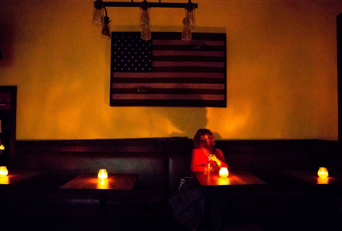 Judy Aquiline, a Sonoma local, sits in the candle-lit restaurant Reel and Brand in Sonoma, California, on October 9, 2019, during a planned power outage by the Pacific Gas & Electric (PG&E) utility company. - Rolling blackouts set to affect millions of Californians began on October 9 as a utility company started switching off power to an unprecedented number of households in the face of hot, windy weather that raises the risk of wildfires.  (BRITTANY HOSEA-SMALL/AFP via Getty Images)