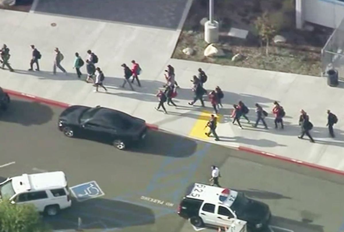 People are lead out of Saugus High School after reports of a shooting on Thursday, Nov. 14, 2019 in Santa Clarita, Calif. The Los Angeles County Sheriff’s Department says on Twitter that deputies are responding to the high school about 30 miles (48 kilometers) northwest of downtown Los Angeles. The sheriff’s office says a male suspect in black clothing was seen at the school.  (KTTV-TV via AP)