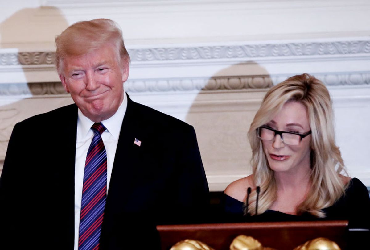 President Donald Trump smiles as pastor Paula White prepares to lead the room in prayer, during a dinner for evangelical leaders in the State Dining Room of the White House, Monday, Aug. 27, 2018, in Washington. () (AP Photo/Alex Brandon)