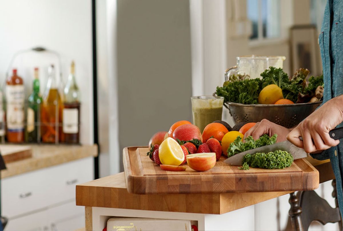 Man cutting produce in the kitchen (Getty Images)