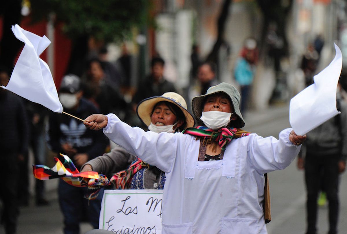 A supporters of Bolivian ex-President Evo Morales waves white flags during clashes with riot police following a protest in La Paz on November 13, 2019. - Bolivia's exiled ex-president Evo Morales said Wednesday he was ready to return to "pacify" his country amid weeks of unrest that led to his resignation. (Photo by JORGE BERNAL / AFP) (Photo by JORGE BERNAL/AFP via Getty Images) (Jorge Bernal/AFP via Getty Images)