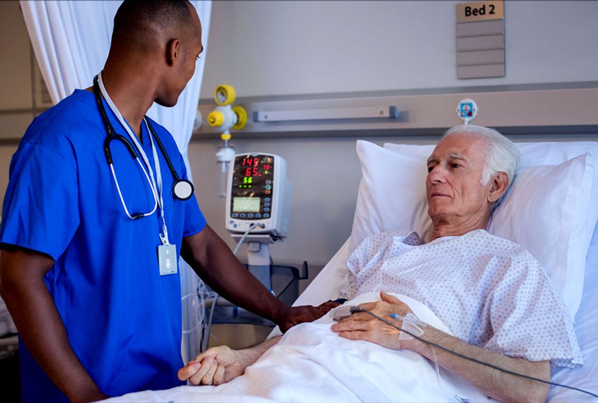 Male nurse doing routine checkup of senior patient in hospital room (Getty Images/Ridofranz)