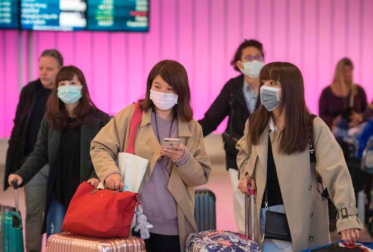  Passengers wear protective masks to protect against the spread of the Coronavirus as they arrive at the Los Angeles International Airport, California, on January 22, 2020. (Mark Ralston/AFP via Getty Images)