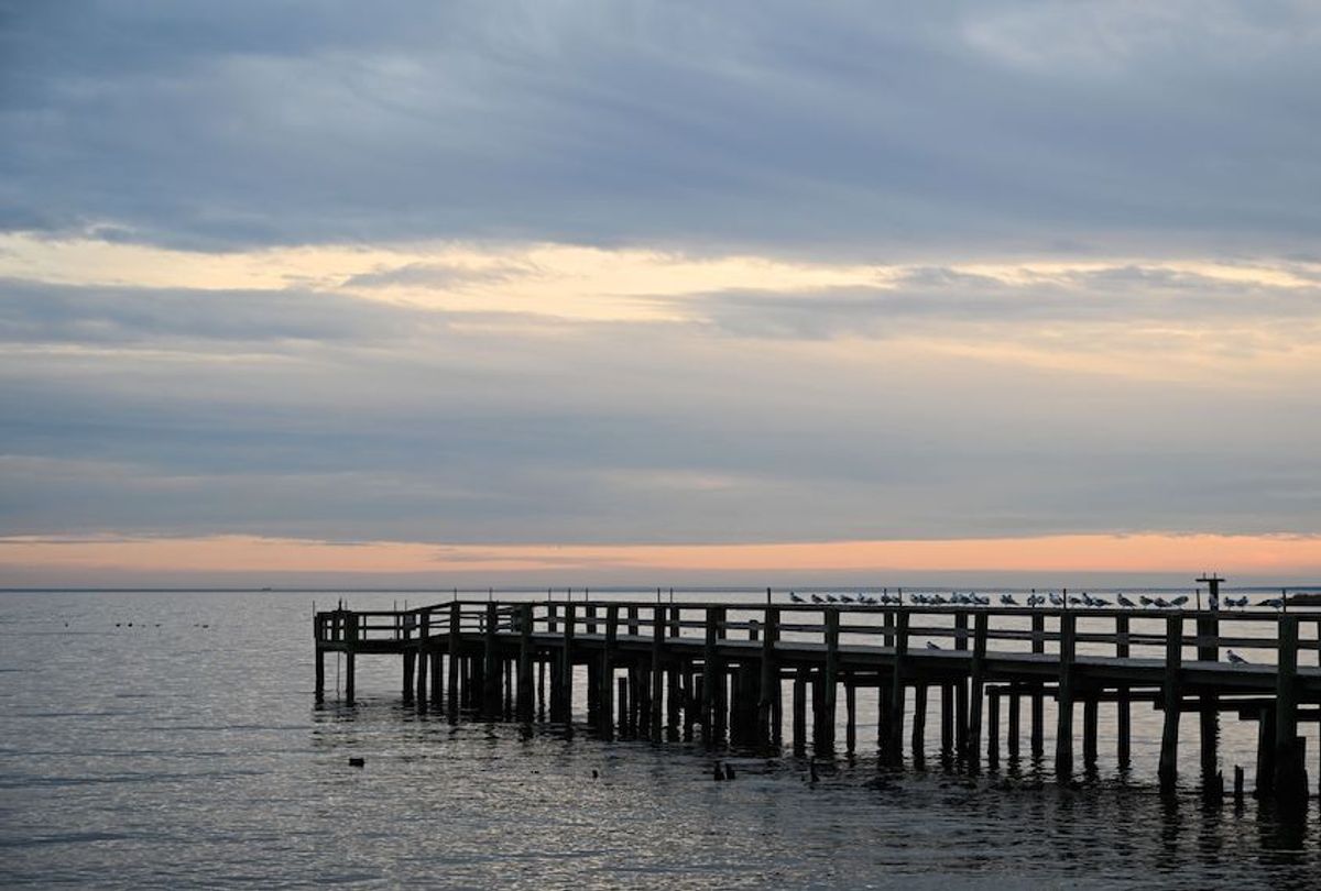 The sun sets over a fishing pier at Columbia Beach in Shady Side, Maryland, January 2, 2020.  (Eva Hambach/AFP via Getty Images)