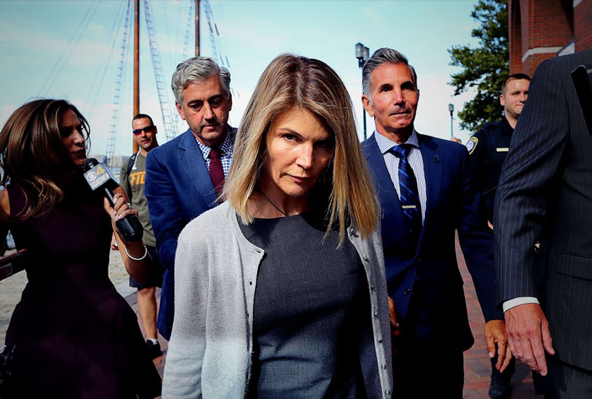 Lori Loughlin, center, and her husband Mossimo Giannulli, behind her at right, leave the John Joseph Moakley United States Courthouse in Boston on Aug. 27, 2019. A judge says actress Lori Loughlin and her fashion designer husband, Mossimo Giannulli, can continue using a law firm that recently represented the University of Southern California. The couple appeared in Boston federal court on Tuesday to settle a dispute over their choice of lawyers in a sweeping college admissions bribery case. Prosecutors had said their lawyers pose a potential conflict of interest. Loughlin and Giannulli say the firms work for USC was unrelated to the admissions case and was handled by different lawyers.  (John Tlumacki/The Boston Globe via Getty Images)