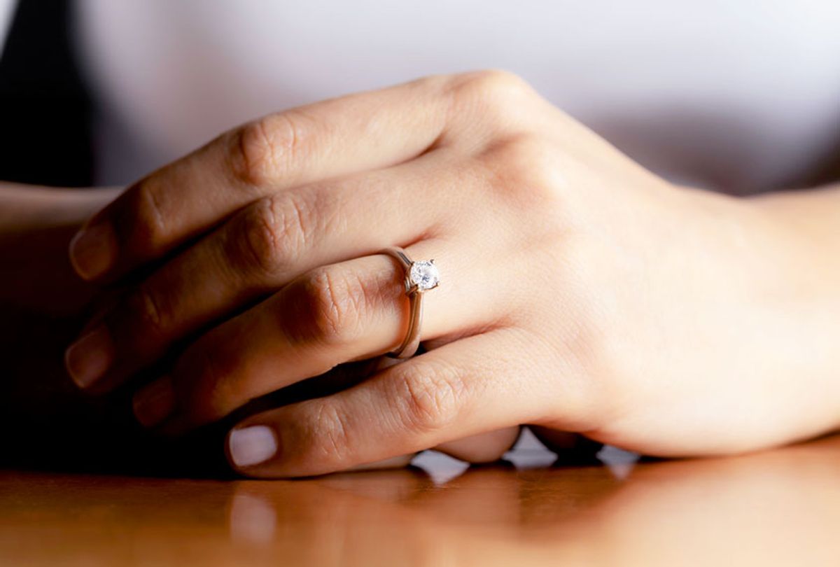Close up of womans hand wearing an engagement ring. (Getty Images)