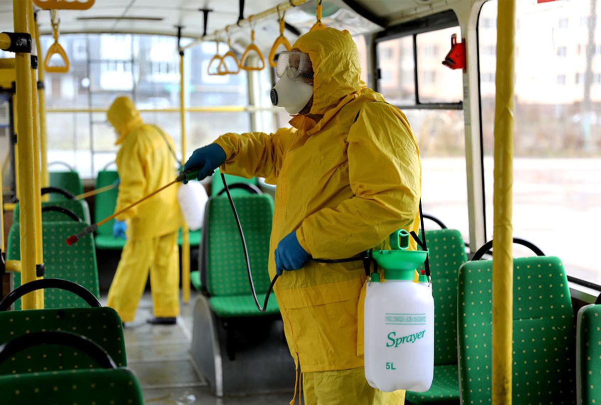 Employees wearing protective gear spray disinfectant to sanitize a passenger bus as a preventive measure against the coronavirus in Lviv, Ukraine, Tuesday, March 3, 2020. Ukrainian Chief sanitary and epidemiological doctor Viktor Liashko has just reported its first confirmed case of the new COVID-19 coronavirus, saying a man who recently arrived from Italy was diagnosed with the virus.  (AP Photo/Mykola Tys)
