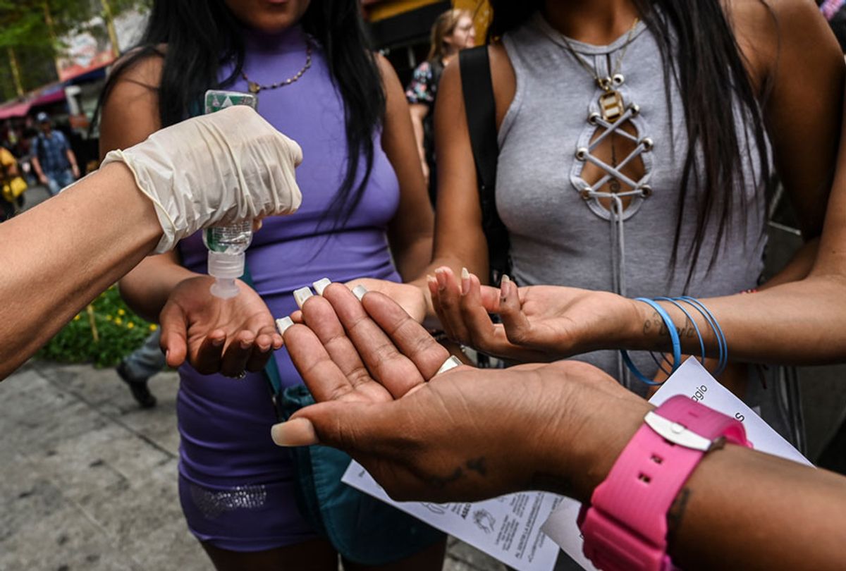 An activist shows sex workers how to apply hand sanitizer during an awareness campaign to promote safe measures against the spread of the new Coronavirus, COVID-19.
 (Joaquin Sarmiento/AFP via Getty Images)
