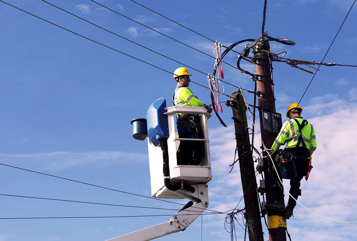 Men up pole working on power lines (Getty Images)
