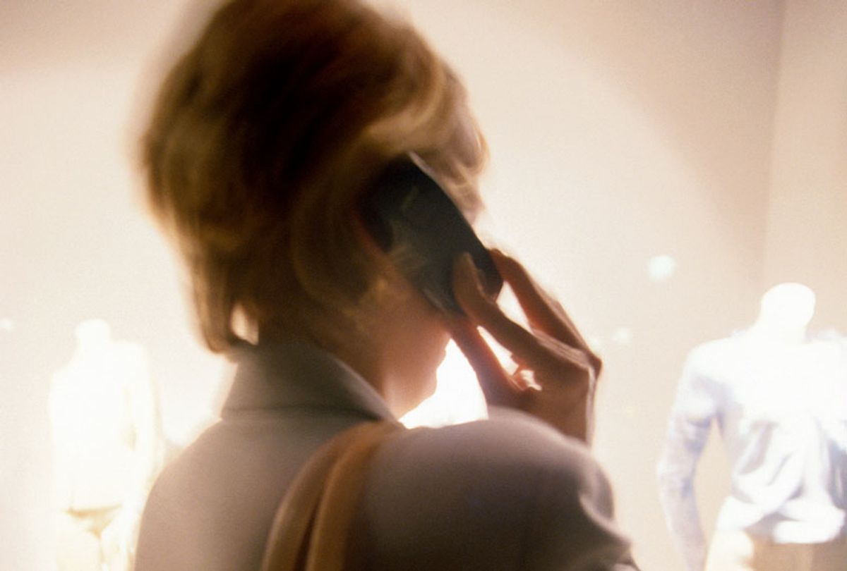 Woman talking on a cell phone, rear view (defocused) (Getty Images/ Brad Rickerby)