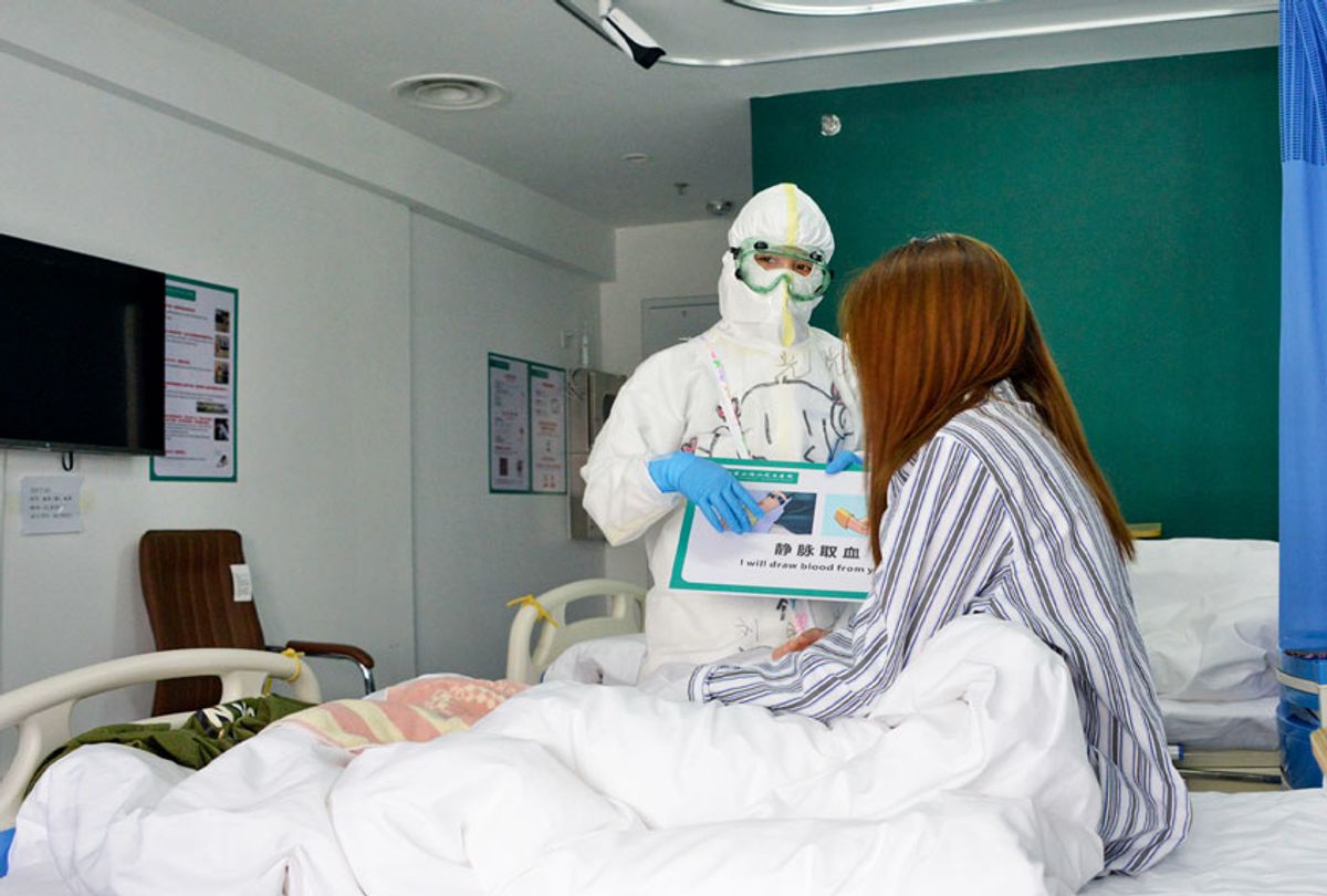 A medical worker communicates with a patient at Xiaotangshan Hospital in Beijing, capital of China, March 30, 2020 (Xinhua/Chen Zhonghao via Getty Images)