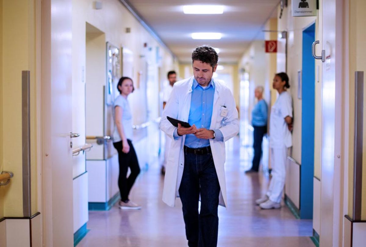 Doctor walking through hospital corridor (Getty Images)