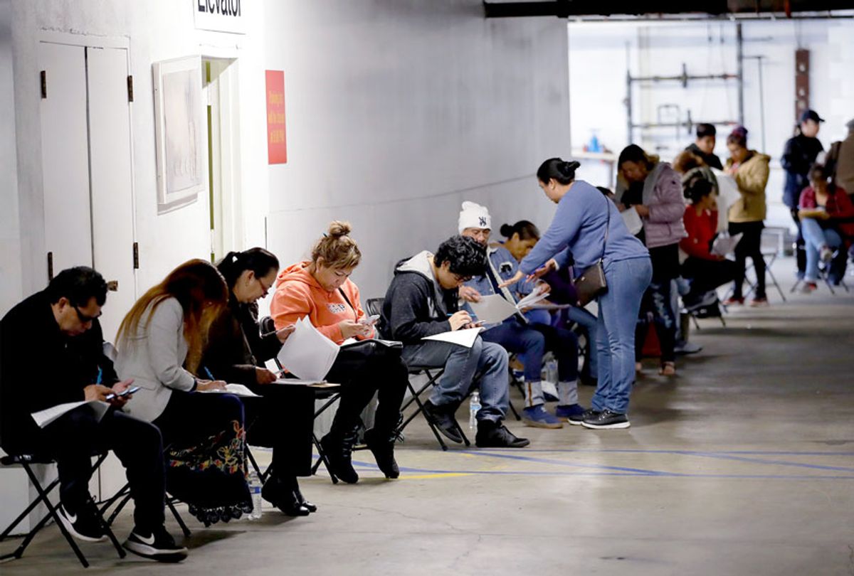 Hospitality workers wait in line in a basement garage to apply for unemployment benefits in the midst of the coronavirus pandemic. (AP Photo/Marcio Jose Sanchez)