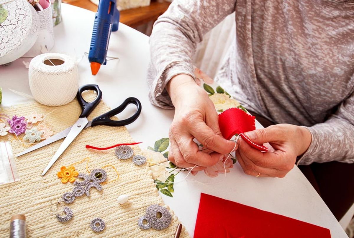 A woman sews by hand and making an ornament (Getty Images)