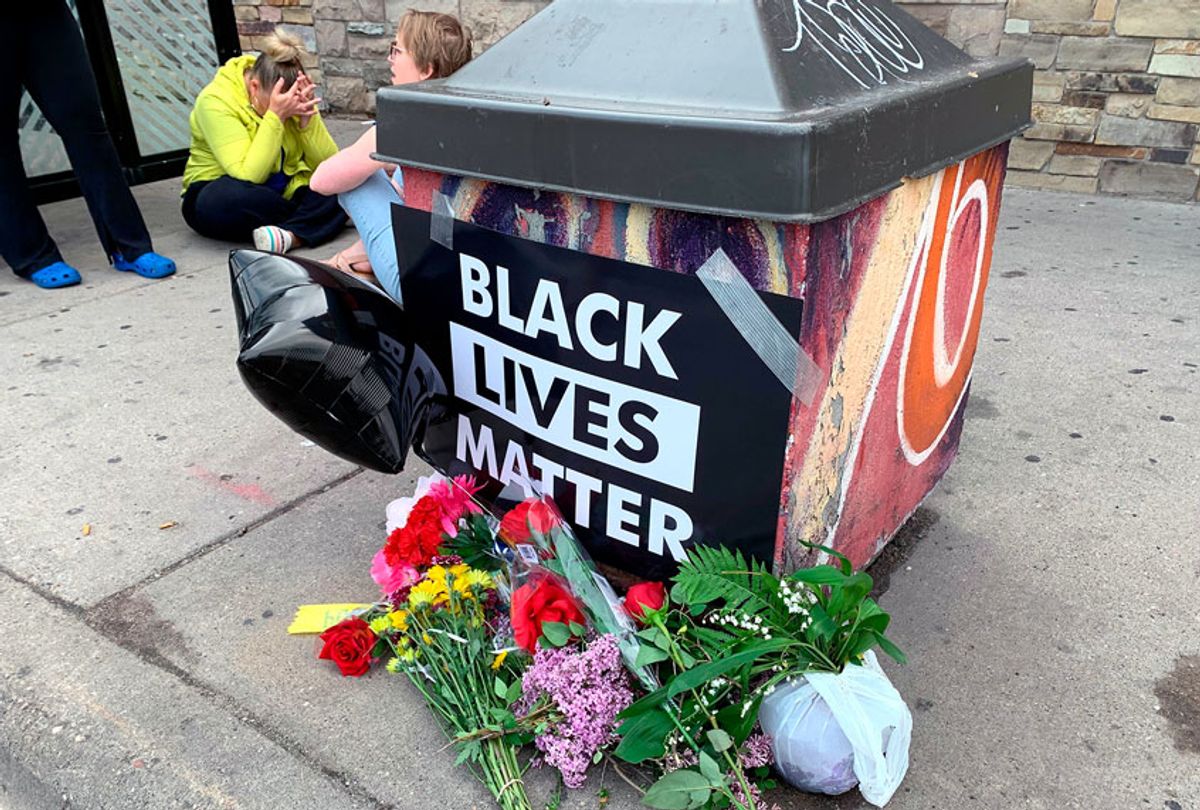 People gather around a makeshift memorial Tuesday, May 26, 2020, in Minneapolis, near where an black man was taken into police custody the day before who later died. (AP Photo/Jeff Baenen)