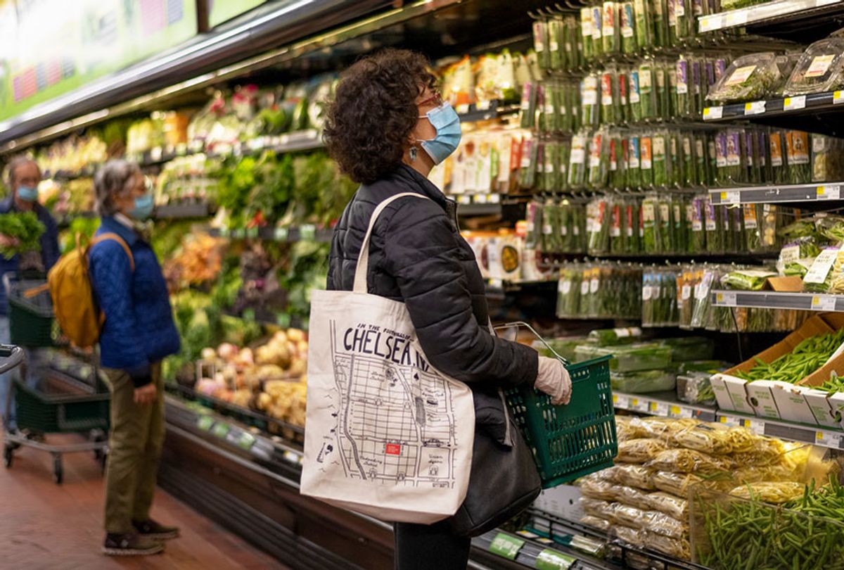A woman wearing a mask and gloves shops at grocery store amid the coronavirus pandemic (Alexi Rosenfeld/Getty Images)