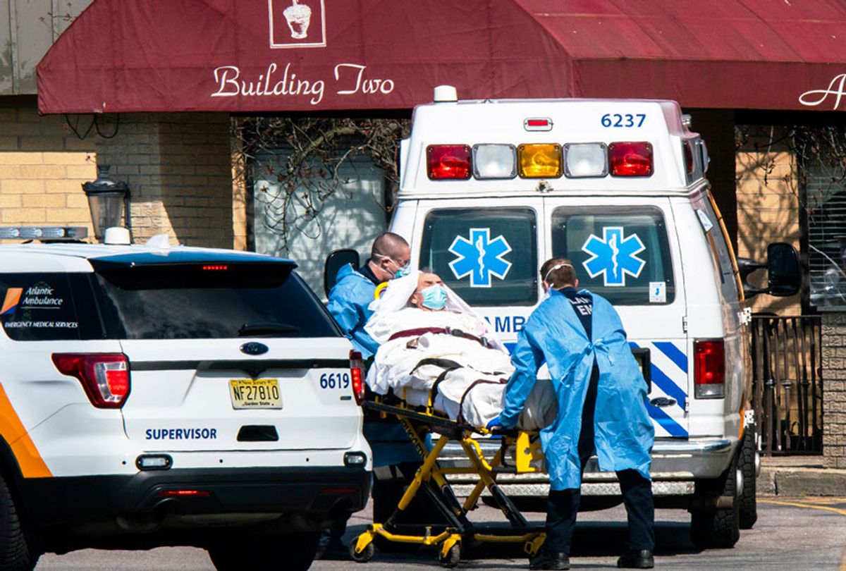 Medical workers load a patient from Andover Subacute and Rehabilitation Center into an ambulance while wearing masks and personal protective equipment (PPE) in Andover, New Jersey. After an anonymous tip to police, 17 people were found dead at the long-term care facility, including two nurses, where at least 76 patients and 41 staff members have tested positive for COVID-19.  (Eduardo Munoz Alvarez/Getty Images)
