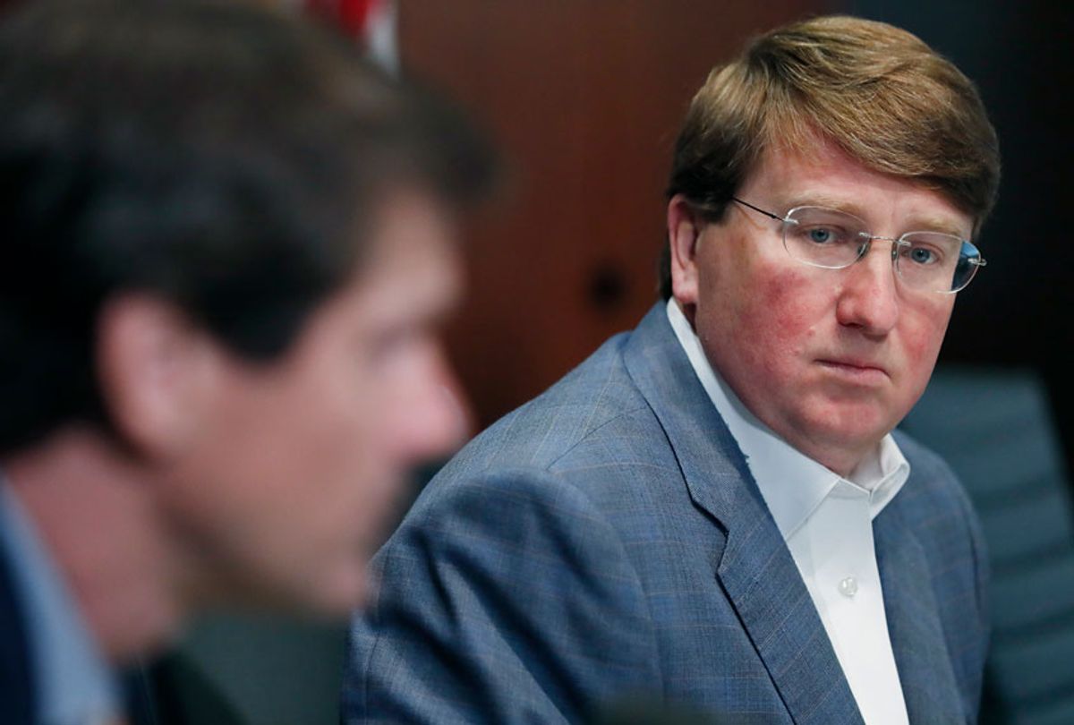 Mississippi Gov. Tate Reeves, left, listens as State Health Officer Dr. Thomas Dobbs speaks about the state's continued efforts in dealing with COVID-19 (AP Photo/Rogelio V. Solis)