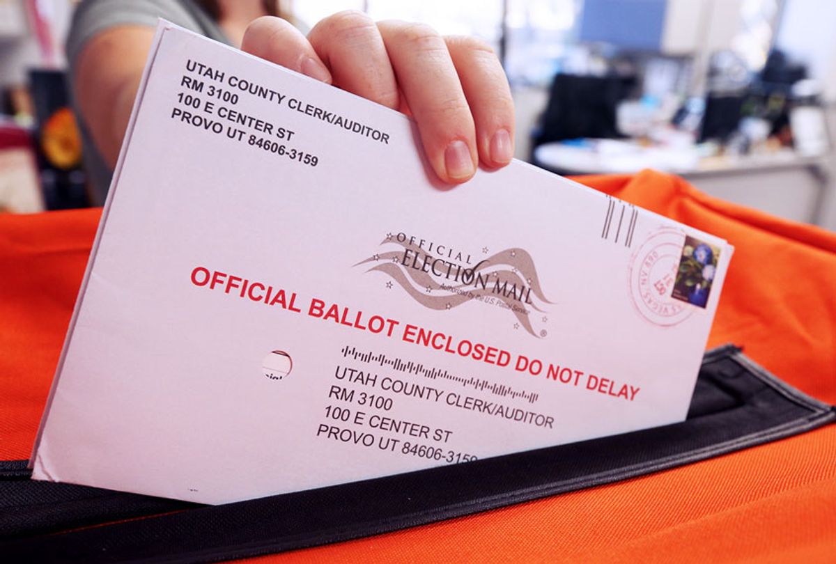 Election office puts mail in ballots into a container  (George Frey/Getty Images)