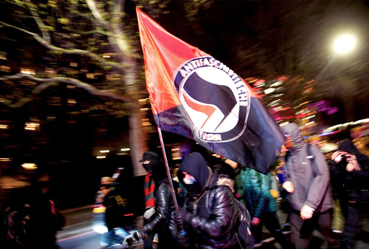 A Man charges with an Anti-Fascist flag (Getty Images)