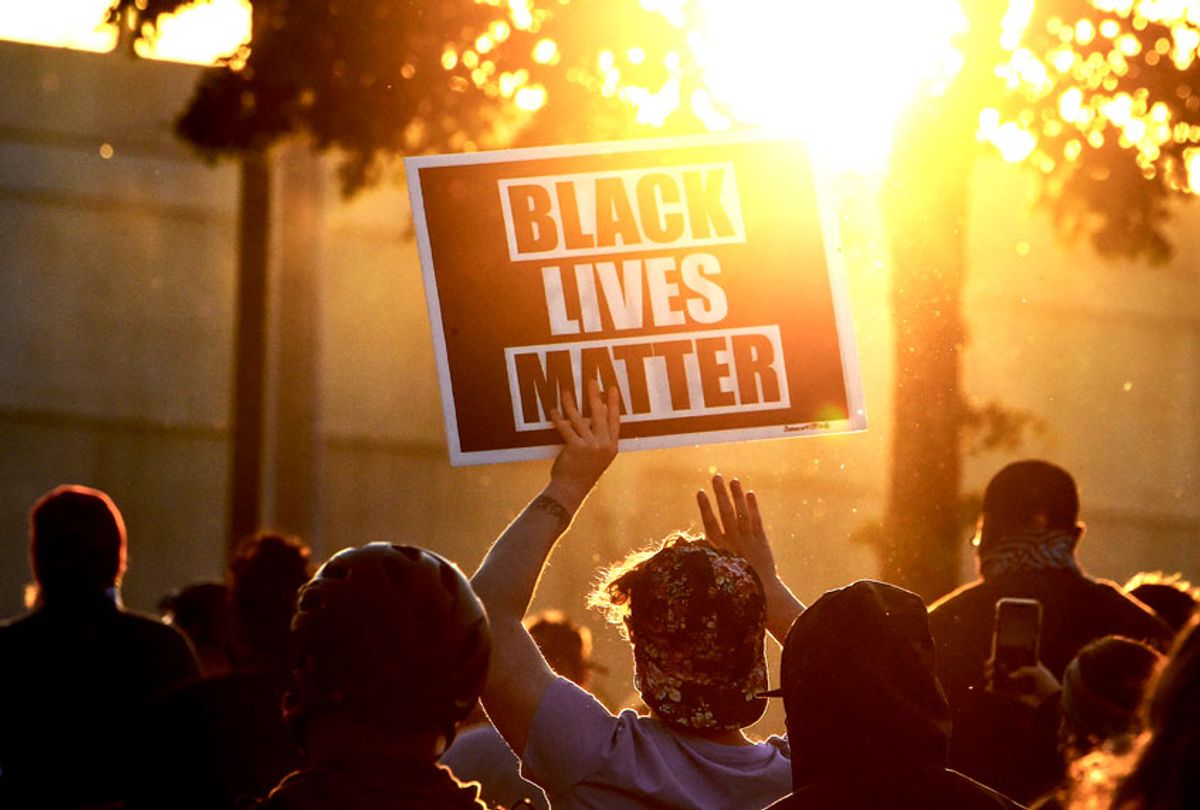 A protestor holds a Black Lives Matter placard (CHANDAN KHANNA/AFP via Getty Images)