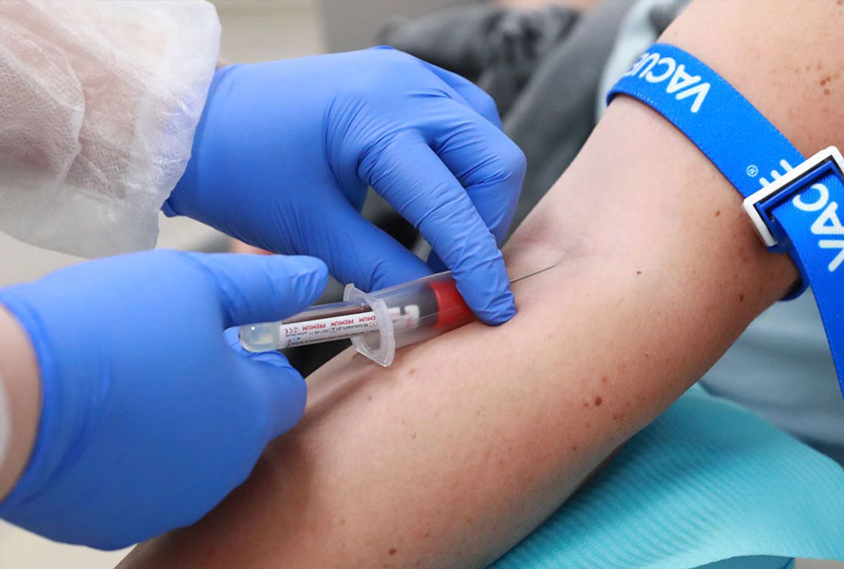 A healthcare worker takes blood samples from a person (Sergei Fadeichev\TASS via Getty Images)