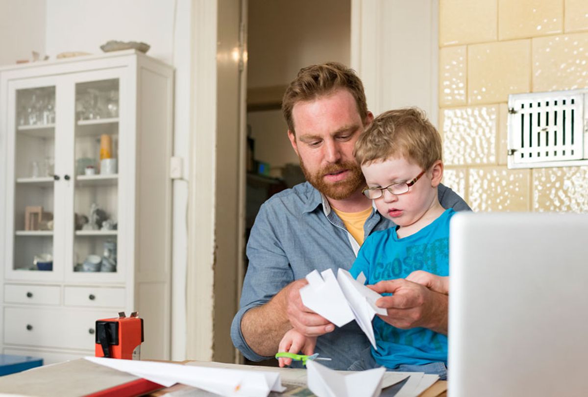 Father and toddler son making paper plane at home  (Getty Images)