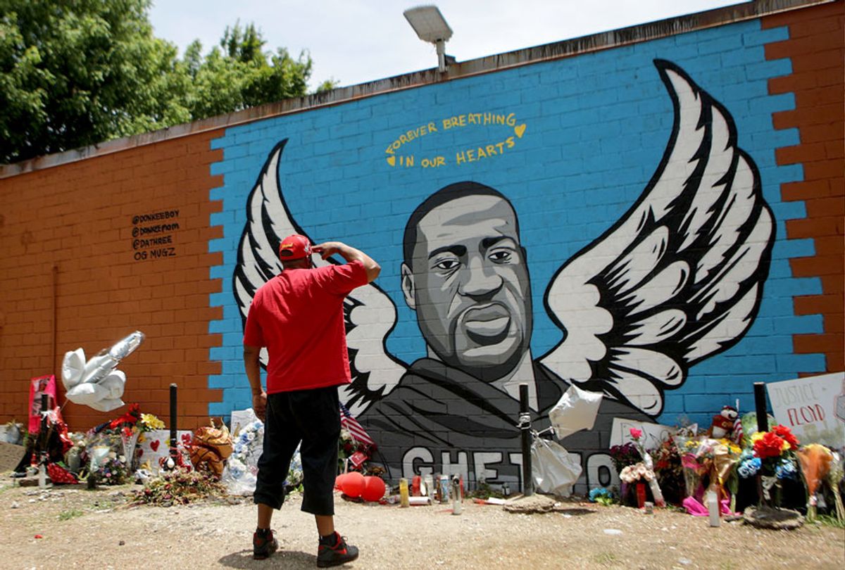 A man salutes at a mural dedicated to George Floyd, across the street from the Cuney Homes housing project in Houston's Third Ward, where Floyd grew up and later mentored young men, on June 10, 2020 in Houston, Texas. (Mario Tama/Getty Images)