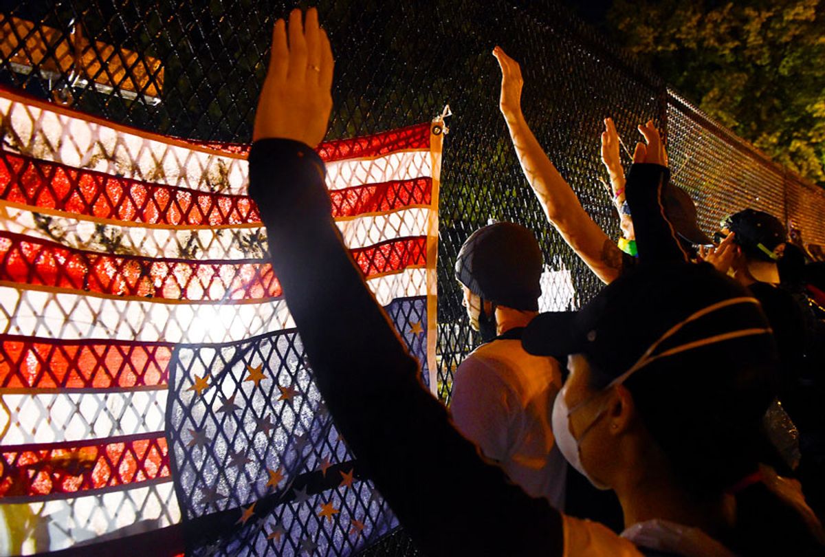 Protesters hold up their hands in front of a recently erected metal fence in front of Lafayette Square near the White House to keep protestors at bay on June 4, 2020 in Washington, DC. (OLIVIER DOULIERY/AFP via Getty Images)