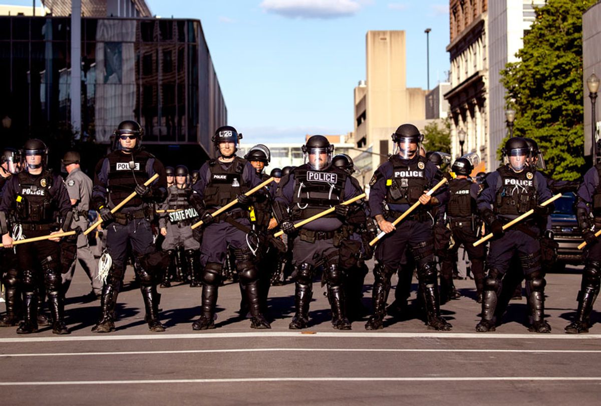 Police officers in riot gear stand in formation at a cross street as they make their way to where protesters are gathered on May 30, 2020 in Louisville, Kentucky. Protests have erupted after recent police-related incidents resulting in the deaths of African-Americans Breonna Taylor in Louisville and George Floyd in Minneapolis, Minnesota. (Brett Carlsen/Getty Images)