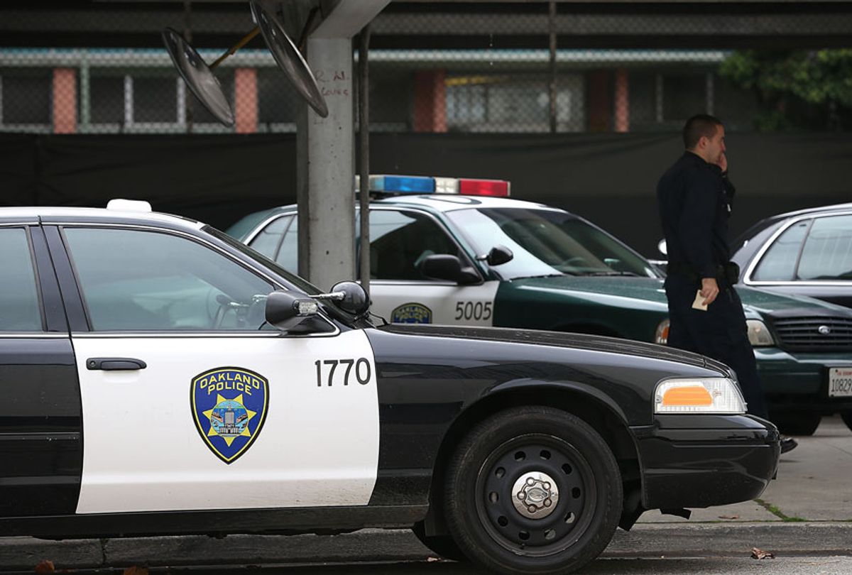 An Oakland Police officer walks by patrol cars at the Oakland Police headquarters (Justin Sullivan/Getty Images)