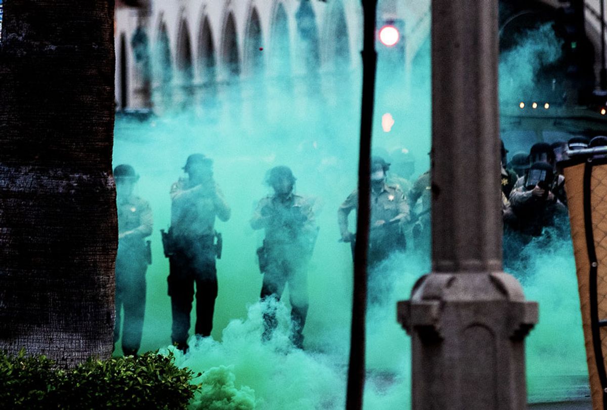Police fire tear gas towards protesters (GinaFerazzi / Los Angeles Times via Getty Images)