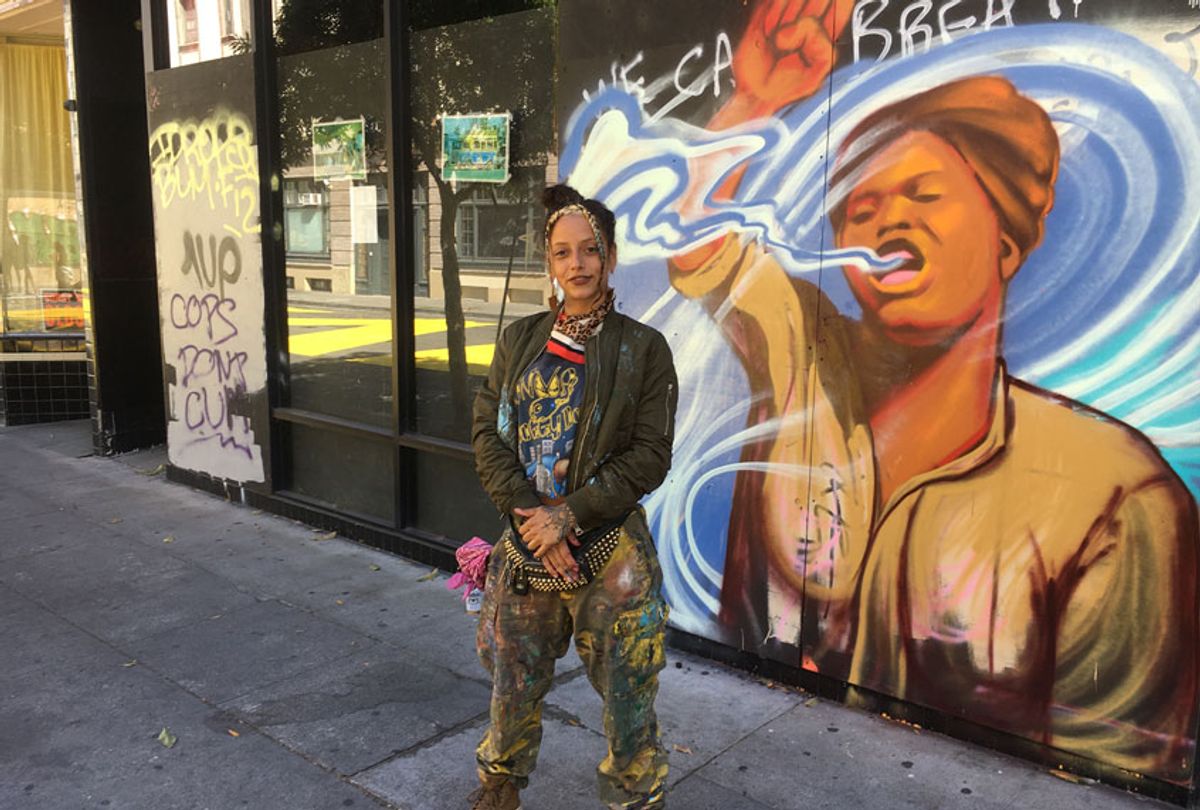Artist Rachel Wolfe-Goldsmith stands in front of her mural "We Can Breathe" in downtown Oakland (Photo courtesy of Rachel Wolfe-Goldsmith)