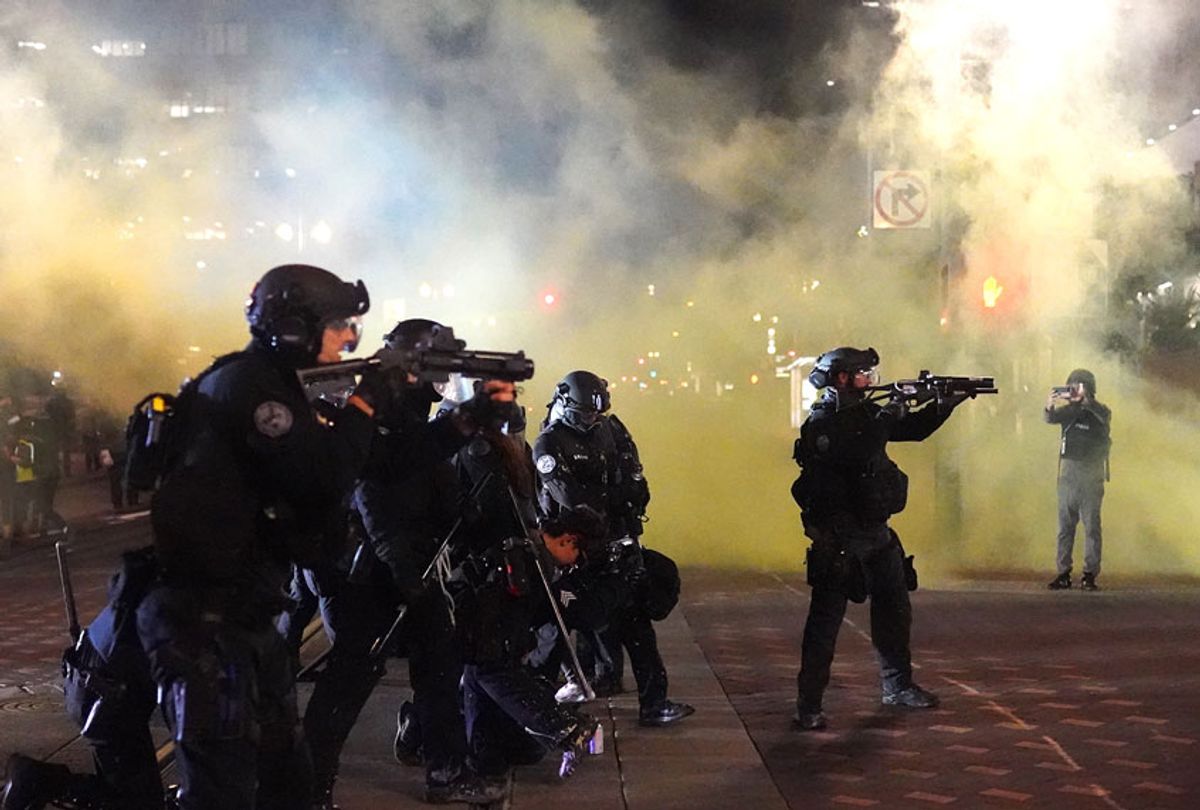 Portland police officers fires less lethal rounds through smoke while dispersing a crowd of about 150 people from Portland City Hall on August 25, 2020 in Portland, Oregon. Crowds chanted in support of Kenosha Wisconsin on the 90th night of protests Tuesday, where demonstrations have continued for days following the police shooting of Jacob Blake. (Nathan Howard/Getty Images)
