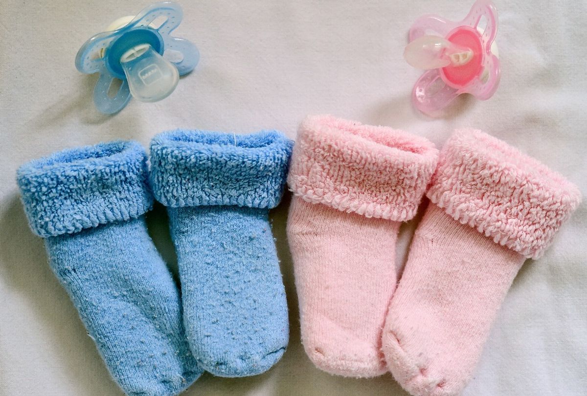 Blue and pink baby booties and pacifiers (Patrick Pleul/picture alliance via Getty Images)