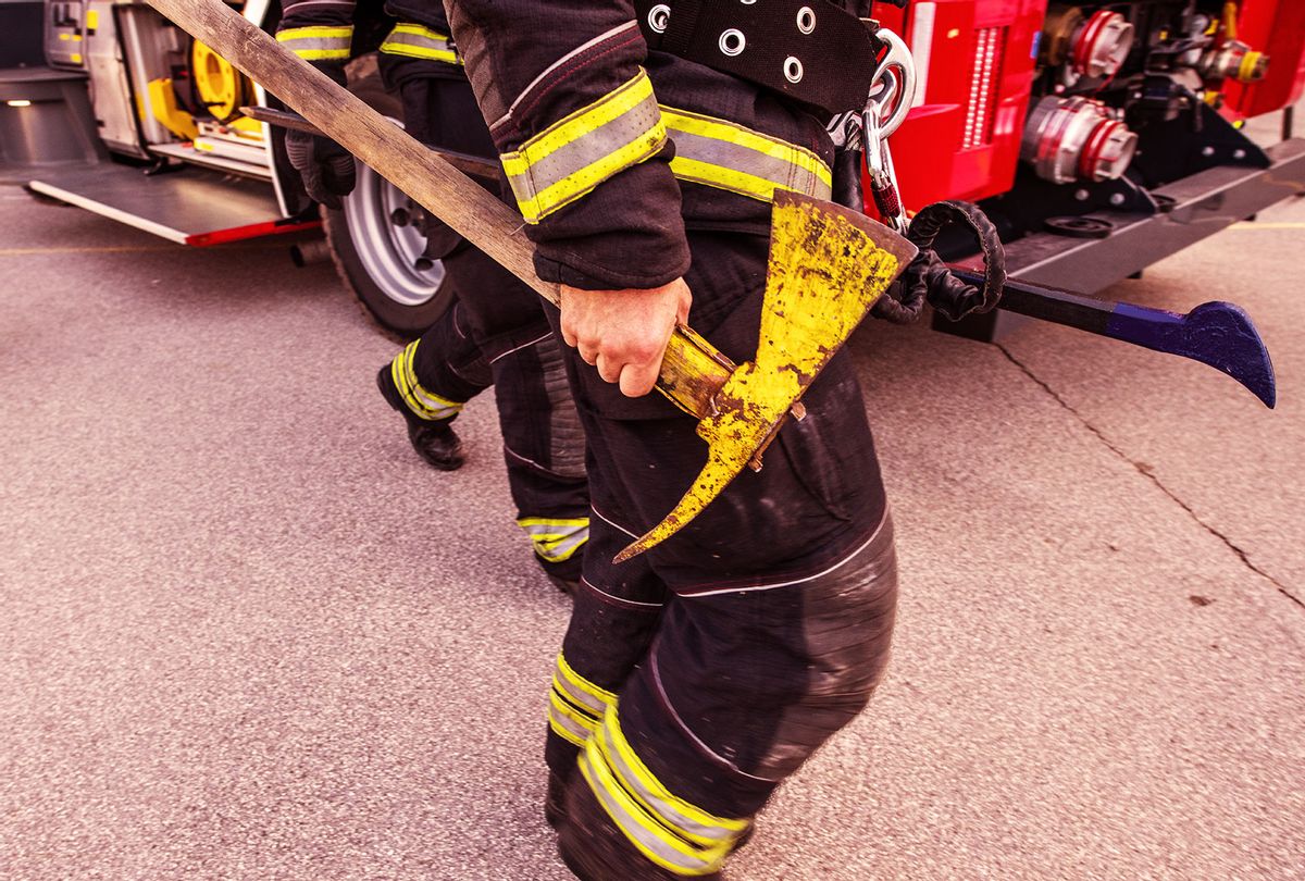 Firefighter holding an axe in his hand (Getty Images)