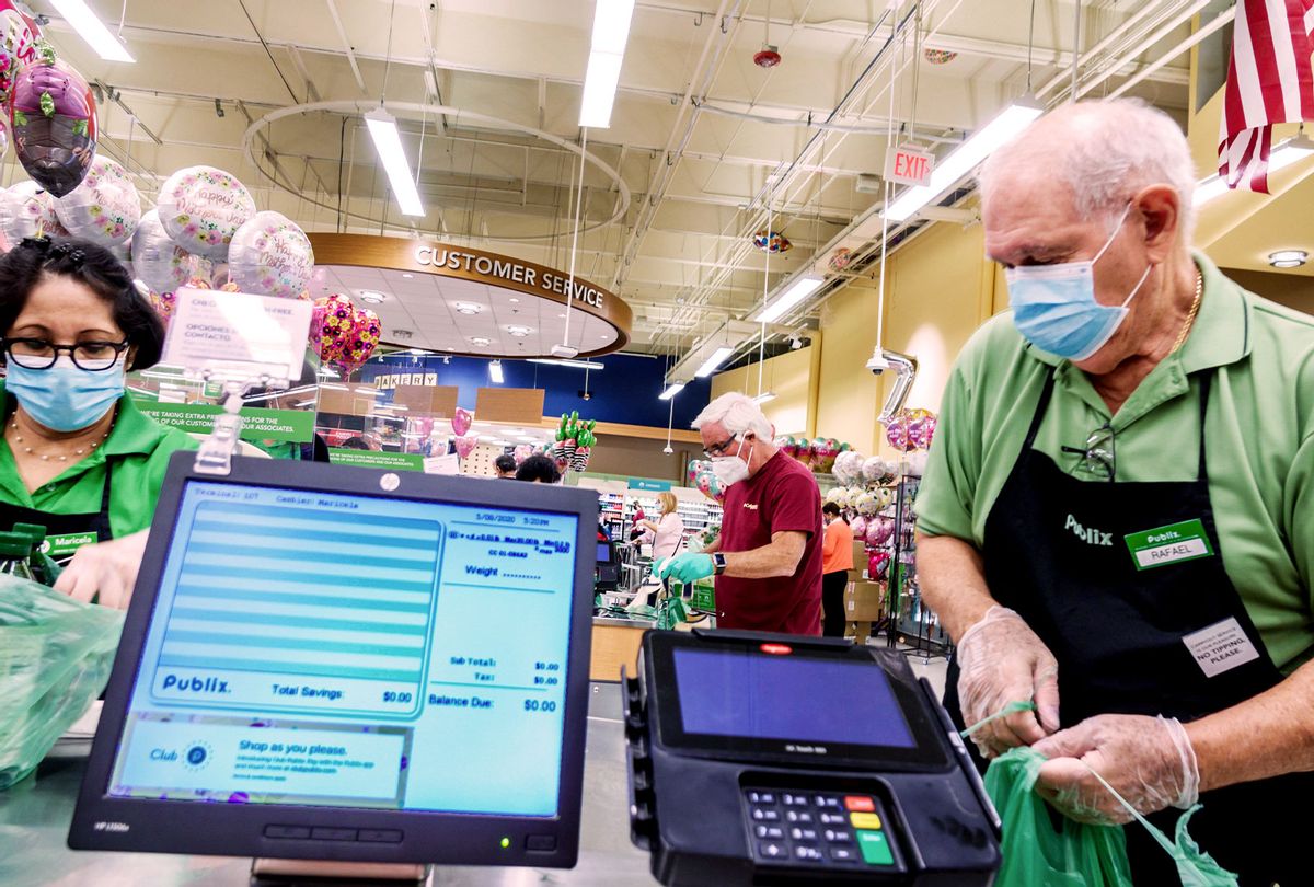 Miami Beach, Publix check out cashier and bagger wearing PPE. (Jeffrey Greenberg/Education Images/Universal Images Group via Getty Images)