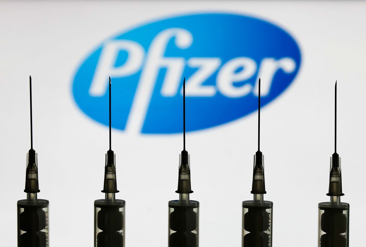 Medical syringes are seen with Pfizer company logo displayed on a screen in the background in this illustration photo taken in Poland on October 12, 2020. (Photo illustration by Jakub Porzycki/NurPhoto via Getty Images)